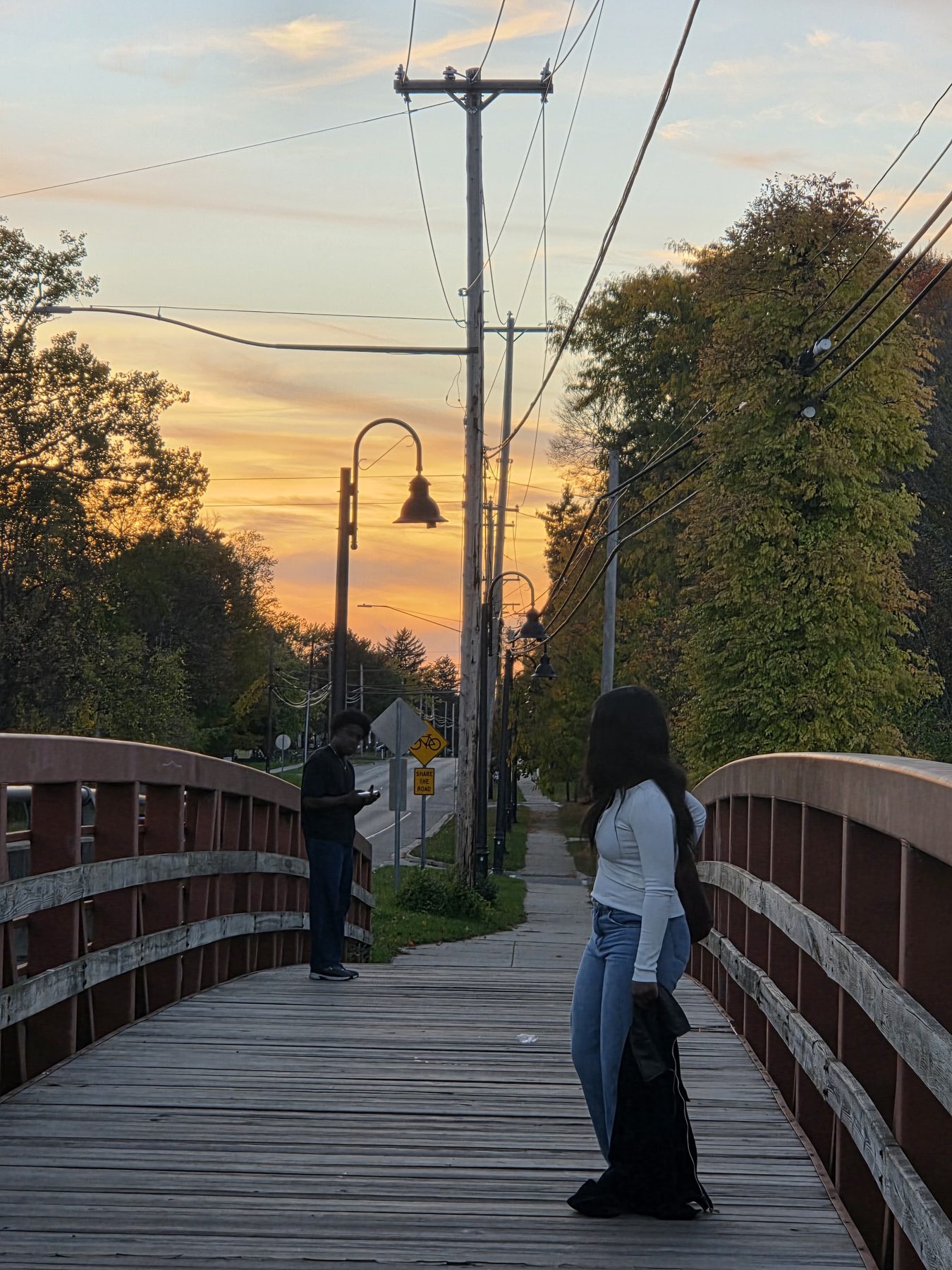 Staged Still, the two of them on the footbridge at sunset